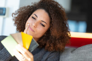 Young woman deciding which card to use for a transaction.