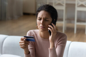 Concerned young woman calls credit card company for extended warranty information.