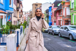 Stylish woman talking on the phone while walking down city street.