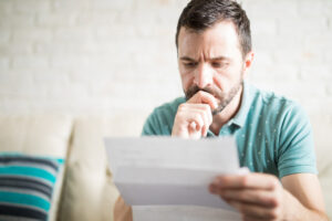 Man reading debt validation letter with concerned look on his face