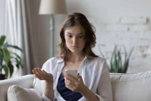 Concerned woman looking at her cellphone.