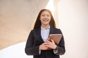 Pleased young woman holds folder of important documents.