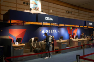 Man checking in with his luggage at the Delta counter in airport.