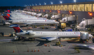Row of Delta flights all parked at airport gates at night