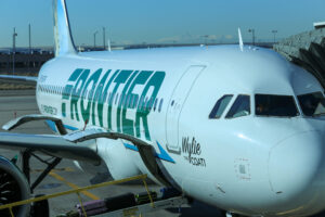 A Frontier airline parked at an airport gate