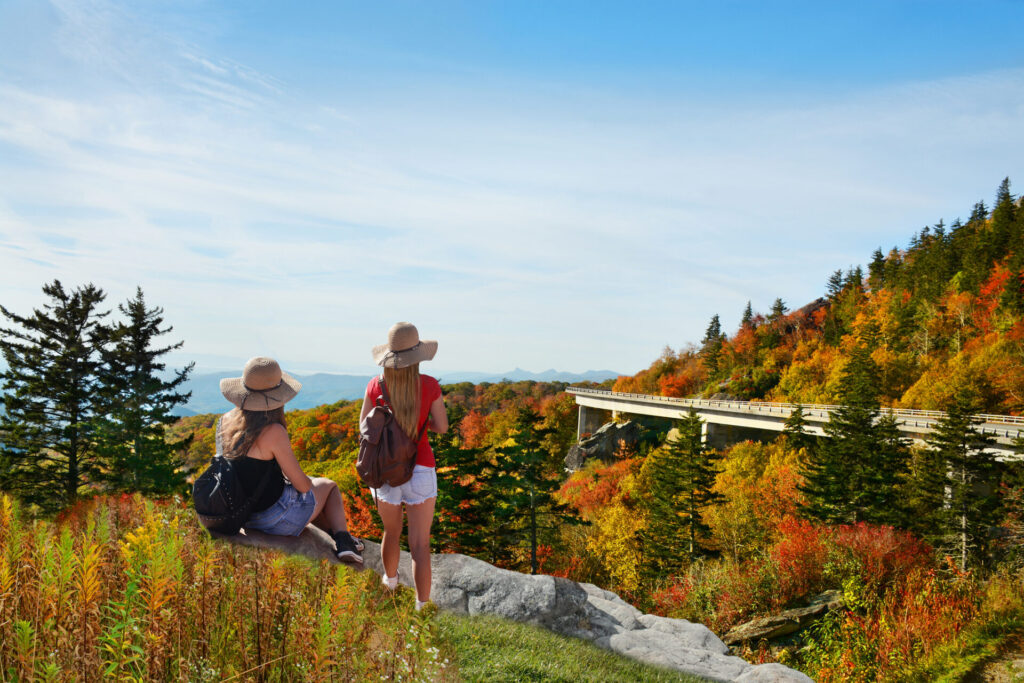 Two girls looking at beautiful mountain autumn view on a hiking trip