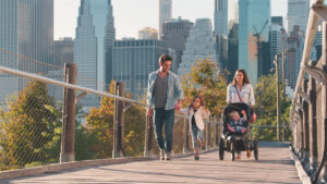 A young family spends a day out in New York City with a stroller and toddler.