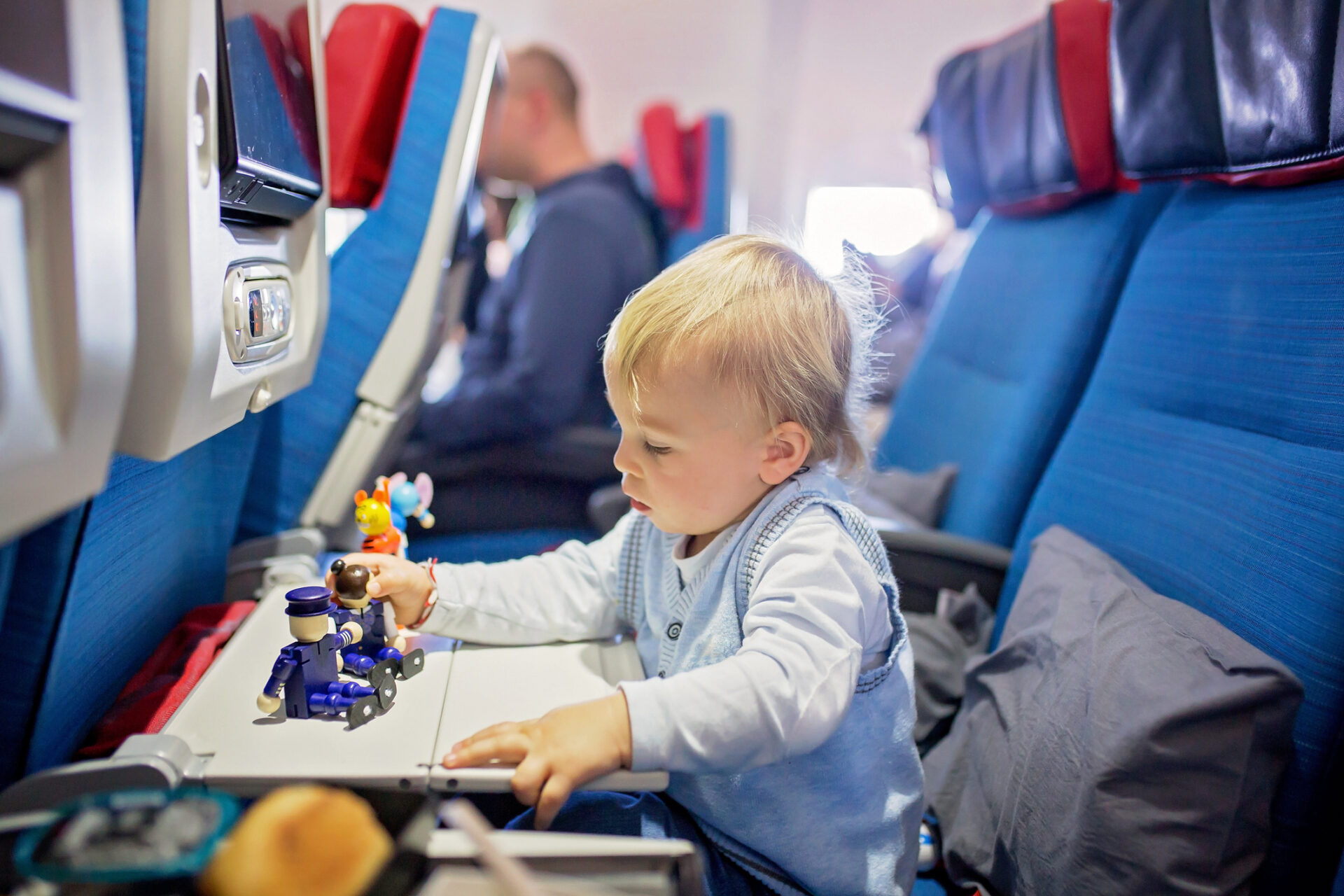 Toddler playing with toys onboard an aircraft.