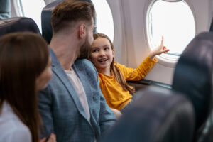 Little girl travels on an airplane with her parents.