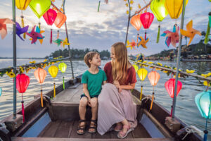 Mother and son on a boat with lanterns in Hoi An, Vietnam