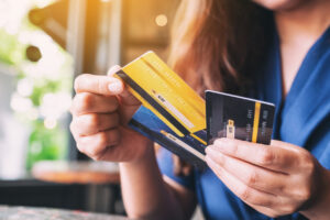 Woman holds several business cards and weighs her options.