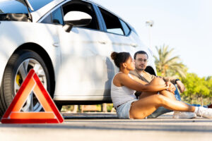 Couple waiting for roadside assistance after car breakdown