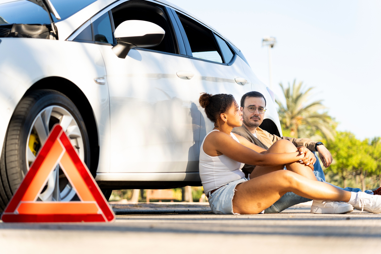 Couple waiting for roadside assistance after car breakdown